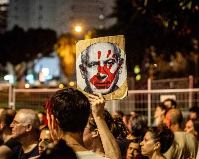 Protesttafel bei Demonstration in Israel mit dem Gesicht Netanjahus