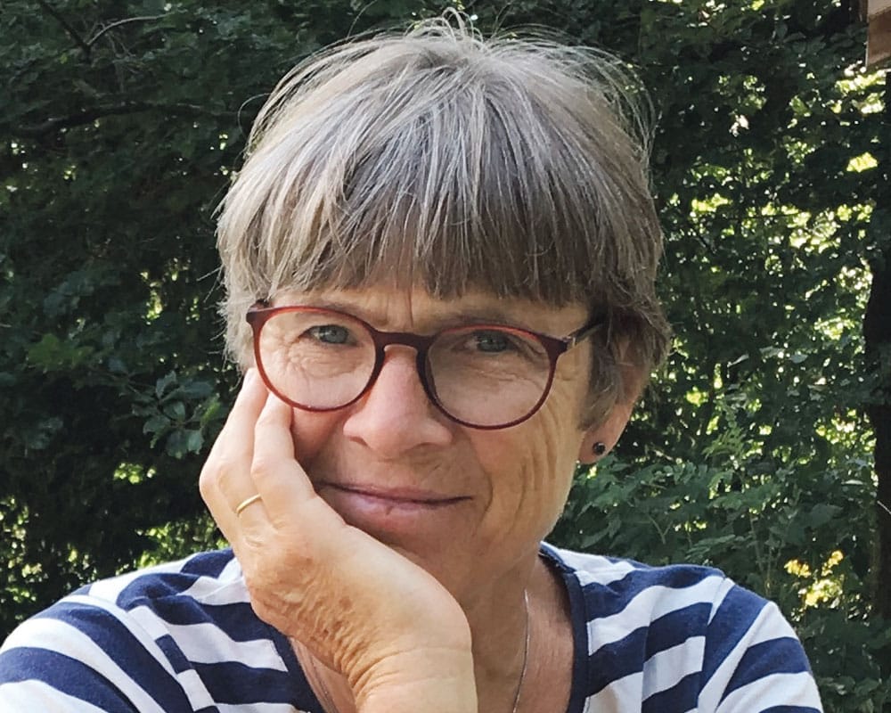 Frau mit grauen Haaren und Brille in einem Ringelshirt