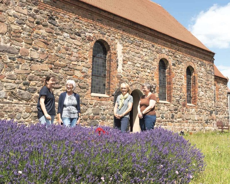 verschiedene Menschen vor einer Kirche aus Stein