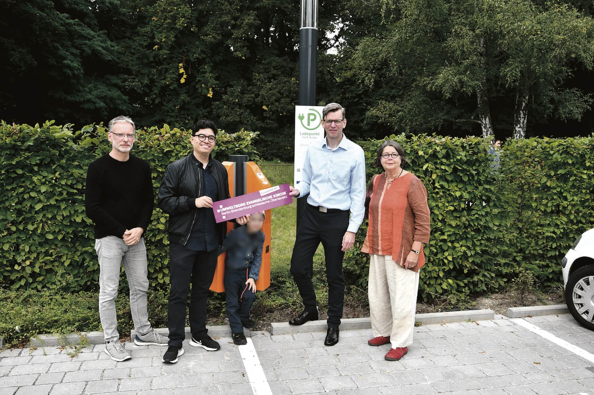 Fünf Personen stehen auf einem Gehweg.