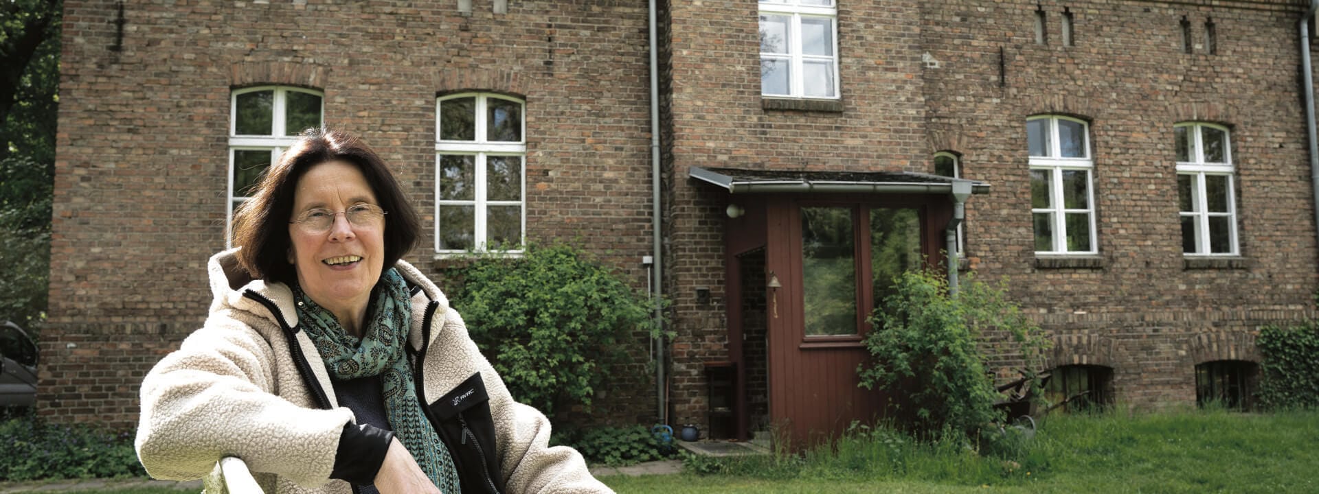 Frau vor einem alten Haus.