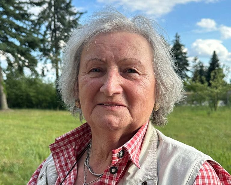 Frau mit grauen Haaren auf einer Wiese