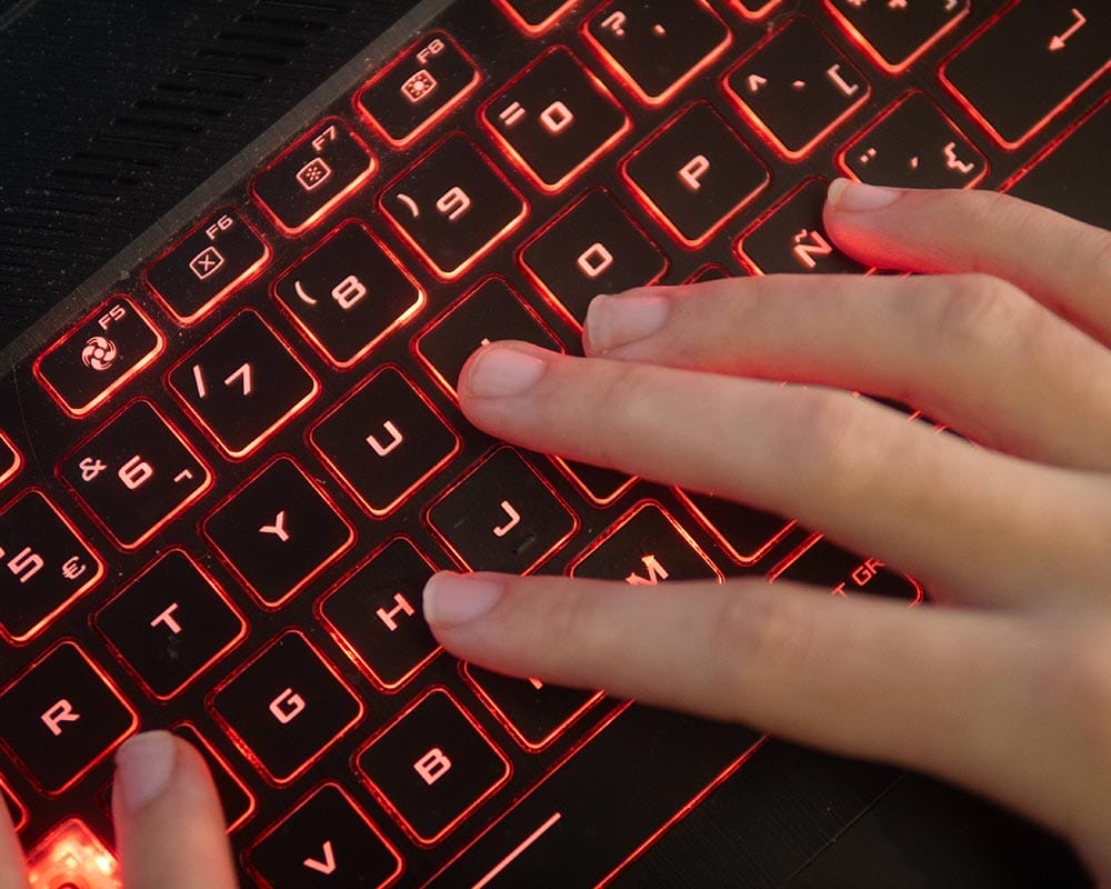 Finger auf rot leuchtender Tastatur