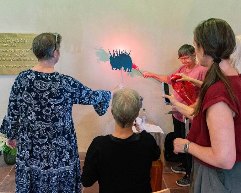 Menschen machen ein Schattentheater an einer Wand