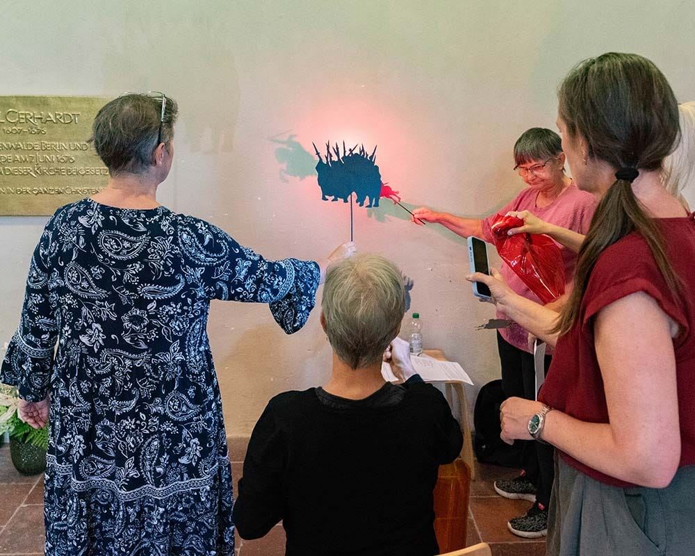 Menschen machen ein Schattentheater an einer Wand