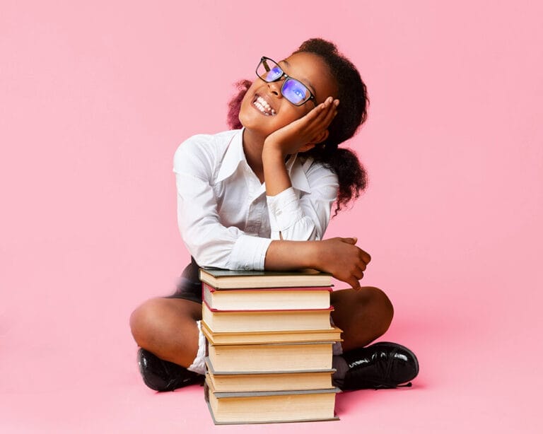 Lächelndes Mädchen mit Büchern vor einem rosafarbenen Hintergrund