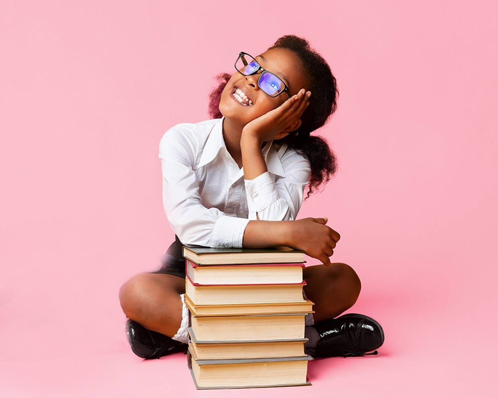 Lächelndes Mädchen mit Büchern vor einem rosafarbenen Hintergrund