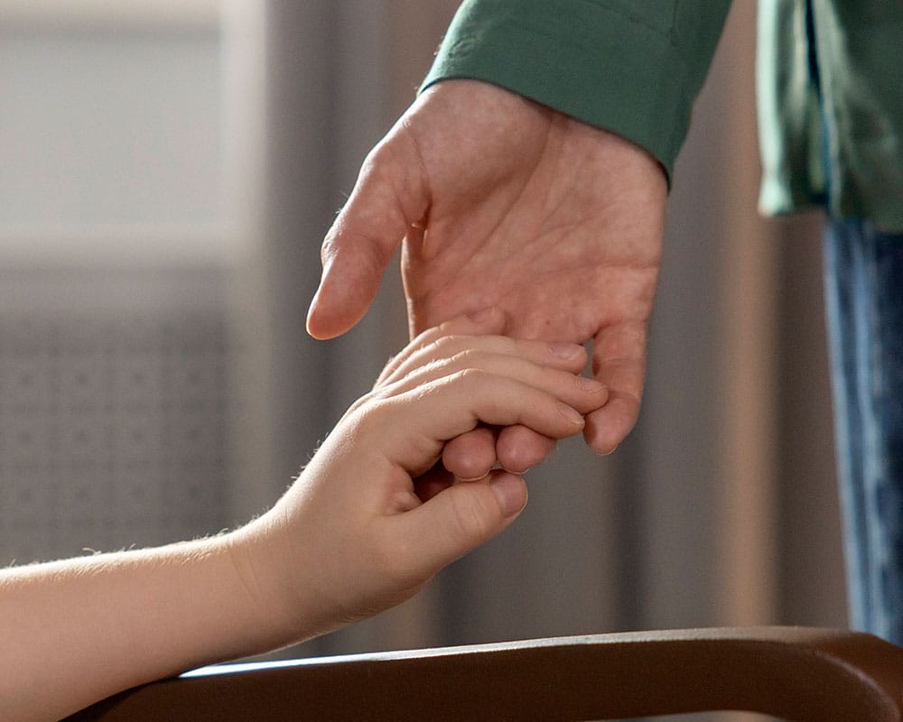 Eine große Hand hält eine kleine Hand